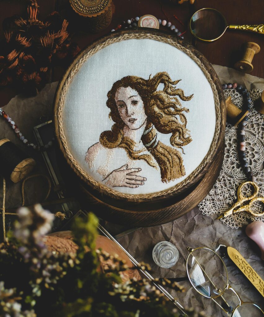 A detailed embroidery of a classical artwork captured in a creative, vintage setting.